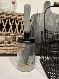 Glazen pot met drie grijze kaarsen